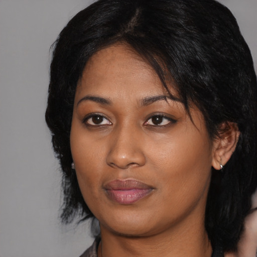 Joyful black young-adult female with medium  black hair and brown eyes