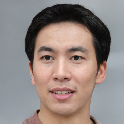 Joyful asian young-adult male with short  black hair and brown eyes
