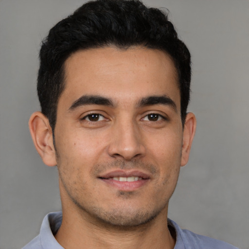 Joyful latino young-adult male with short  brown hair and brown eyes