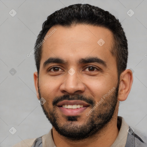 Joyful latino young-adult male with short  black hair and brown eyes