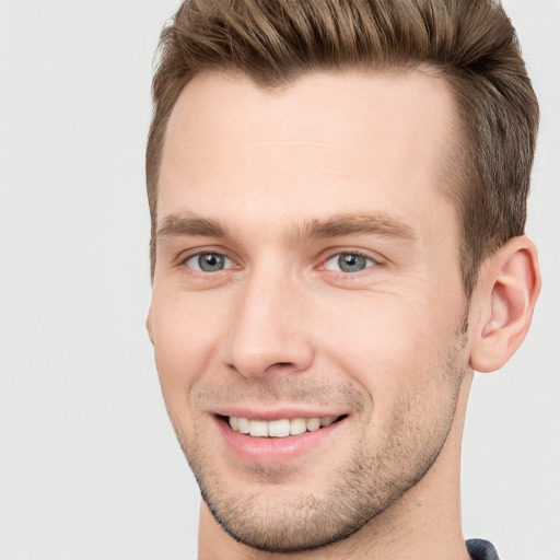 Joyful white young-adult male with short  brown hair and grey eyes