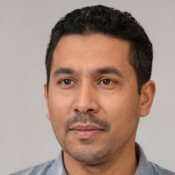 Neutral latino adult male with short  black hair and brown eyes
