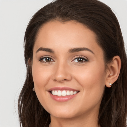 Joyful white young-adult female with long  brown hair and brown eyes