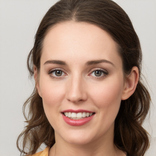 Joyful white young-adult female with medium  brown hair and green eyes