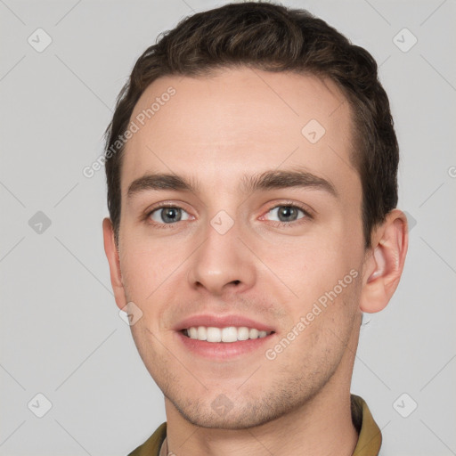 Joyful white young-adult male with short  brown hair and grey eyes