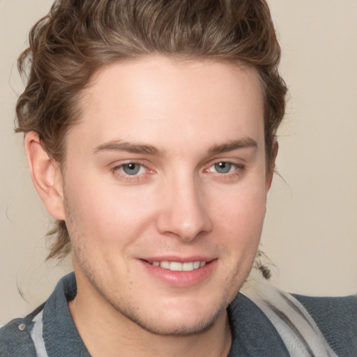 Joyful white young-adult male with medium  brown hair and blue eyes