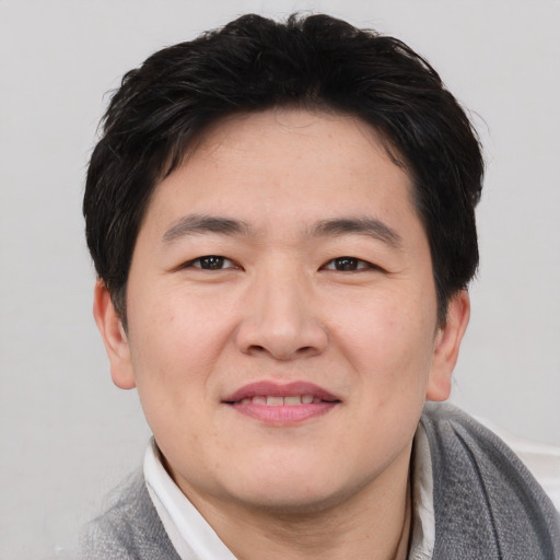 Joyful asian young-adult male with short  black hair and brown eyes