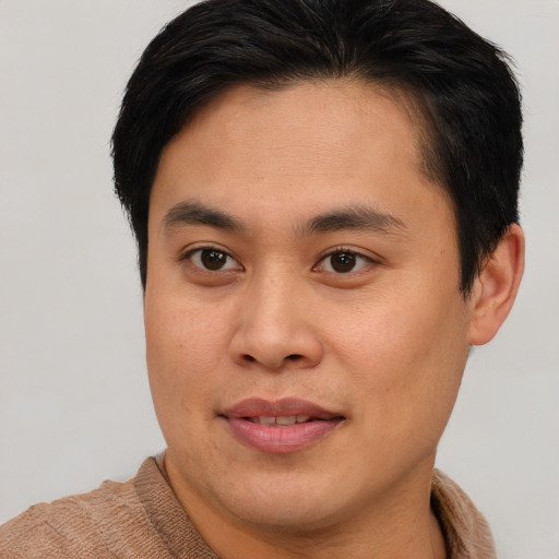 Joyful asian young-adult male with short  brown hair and brown eyes