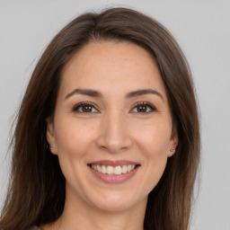 Joyful white young-adult female with long  brown hair and brown eyes