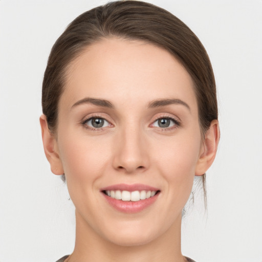 Joyful white young-adult female with medium  brown hair and grey eyes