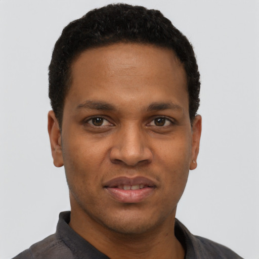 Joyful black young-adult male with short  black hair and brown eyes