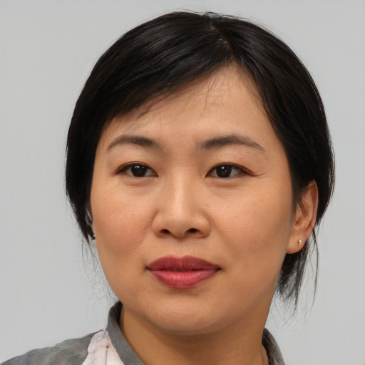 Joyful asian adult female with medium  brown hair and brown eyes