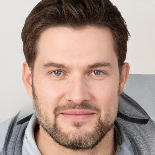 Joyful white young-adult male with short  brown hair and grey eyes