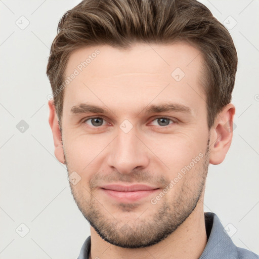 Joyful white young-adult male with short  brown hair and grey eyes