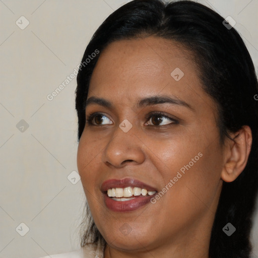 Joyful black young-adult female with long  brown hair and brown eyes