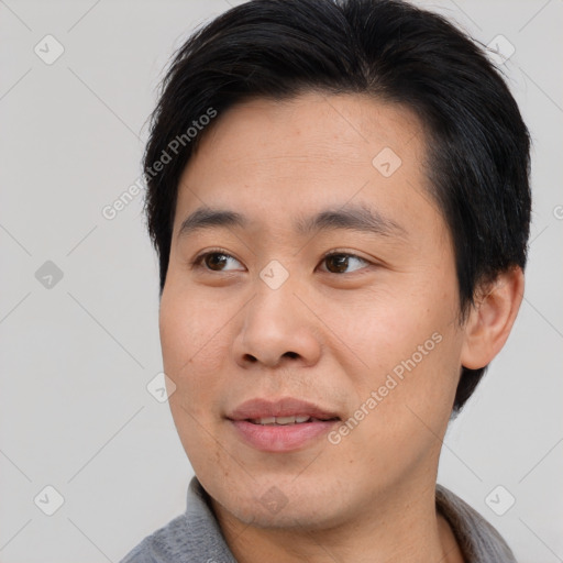 Joyful asian young-adult male with short  black hair and brown eyes