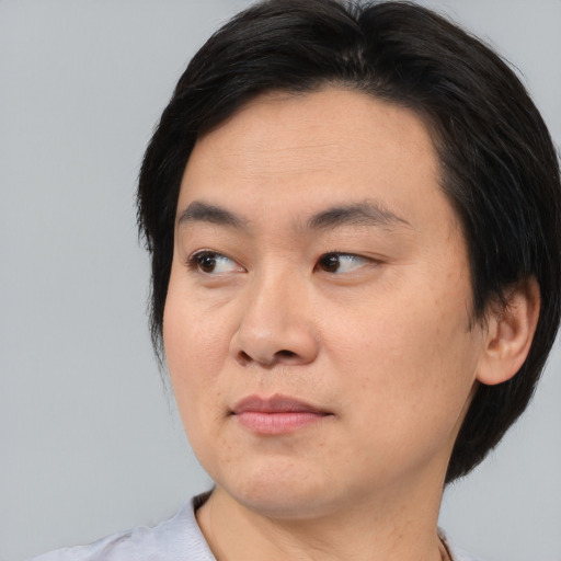 Joyful asian young-adult male with medium  black hair and brown eyes