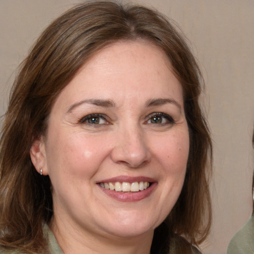 Joyful white adult female with medium  brown hair and grey eyes