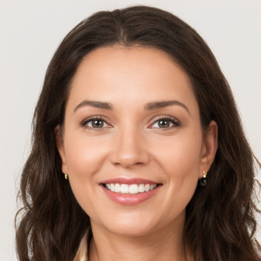 Joyful white young-adult female with long  brown hair and brown eyes