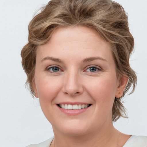 Joyful white young-adult female with medium  brown hair and blue eyes