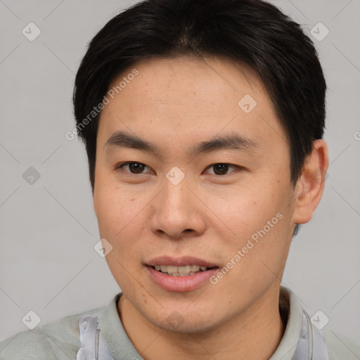 Joyful asian young-adult male with short  brown hair and brown eyes