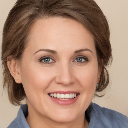 Joyful white young-adult female with medium  brown hair and grey eyes