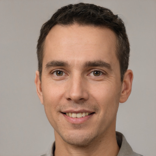 Joyful white young-adult male with short  brown hair and brown eyes