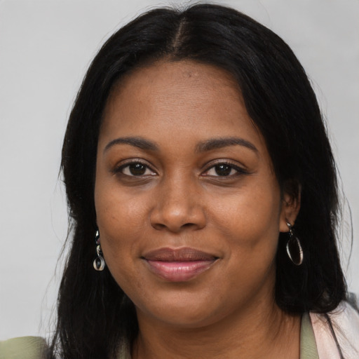 Joyful black young-adult female with long  black hair and brown eyes
