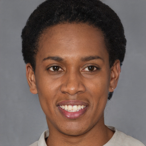 Joyful black young-adult female with short  black hair and brown eyes