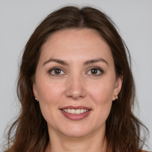 Joyful white young-adult female with long  brown hair and brown eyes