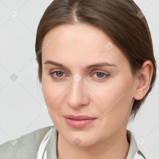 Joyful white young-adult female with medium  brown hair and grey eyes