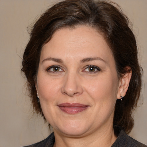 Joyful white adult female with medium  brown hair and brown eyes