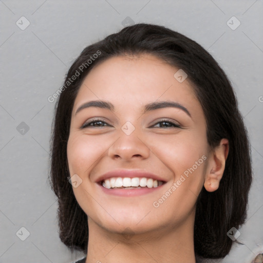 Joyful white young-adult female with long  black hair and brown eyes