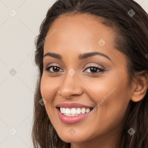 Joyful latino young-adult female with long  brown hair and brown eyes