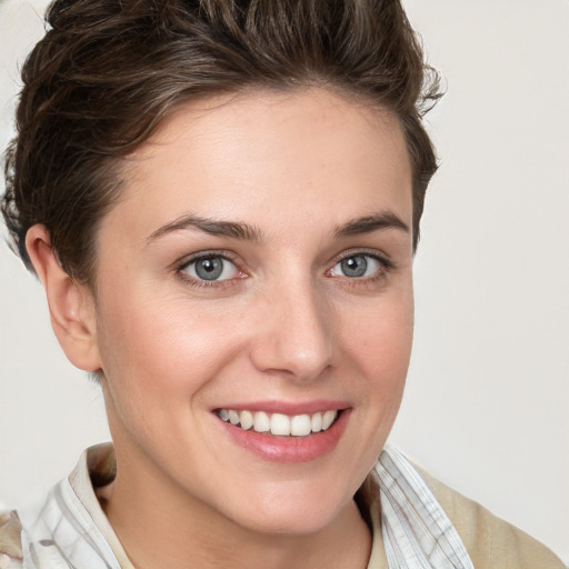 Joyful white young-adult female with short  brown hair and grey eyes