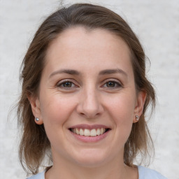 Joyful white young-adult female with medium  brown hair and grey eyes