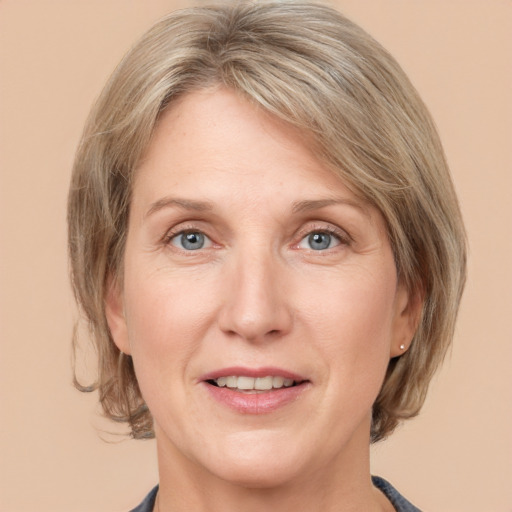 Joyful white adult female with medium  brown hair and grey eyes