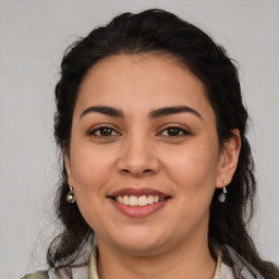 Joyful latino young-adult female with medium  brown hair and brown eyes