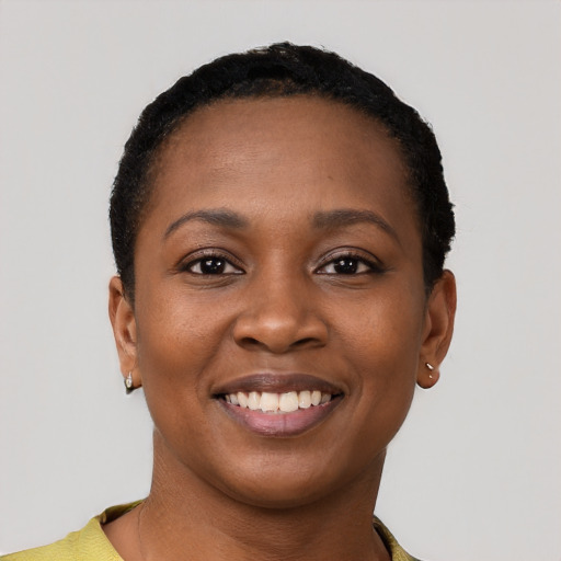 Joyful black young-adult female with short  black hair and brown eyes