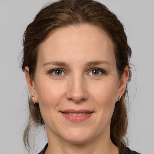 Joyful white adult female with medium  brown hair and grey eyes