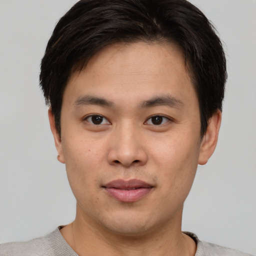 Joyful asian young-adult male with short  brown hair and brown eyes