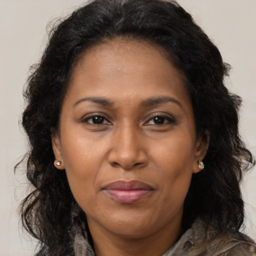 Joyful black adult female with long  brown hair and brown eyes