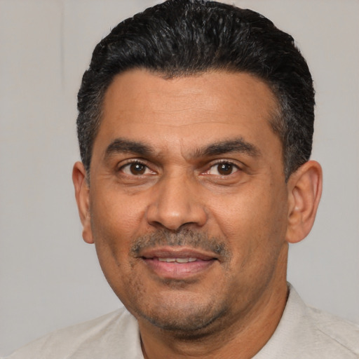 Joyful latino adult male with short  black hair and brown eyes