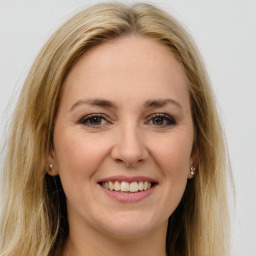 Joyful white young-adult female with long  brown hair and green eyes