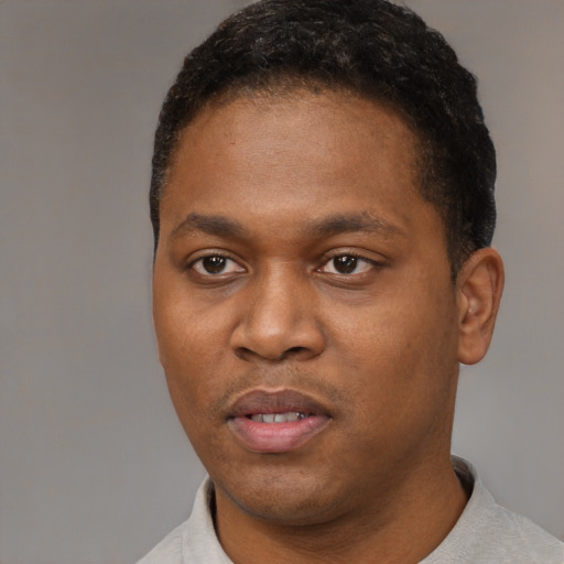 Joyful black young-adult male with short  black hair and brown eyes