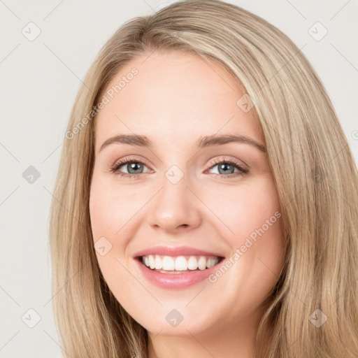 Joyful white young-adult female with long  brown hair and blue eyes