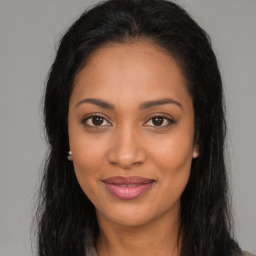 Joyful latino young-adult female with long  brown hair and brown eyes