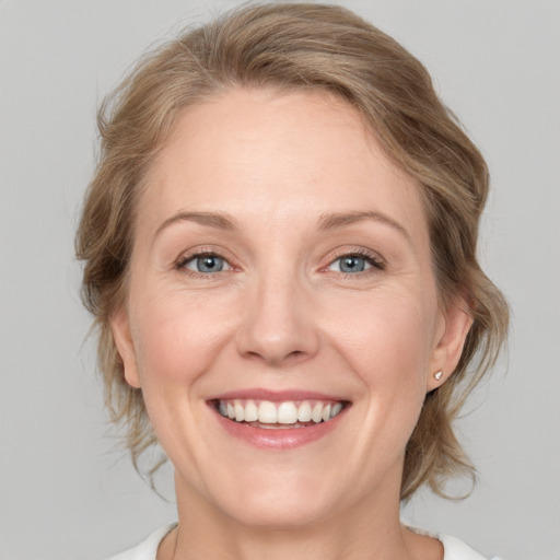 Joyful white adult female with medium  brown hair and blue eyes