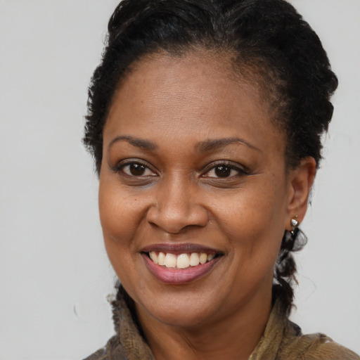 Joyful black adult female with short  brown hair and brown eyes