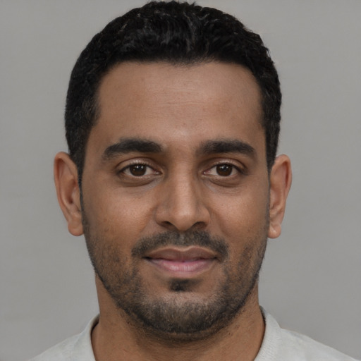 Joyful black young-adult male with short  black hair and brown eyes